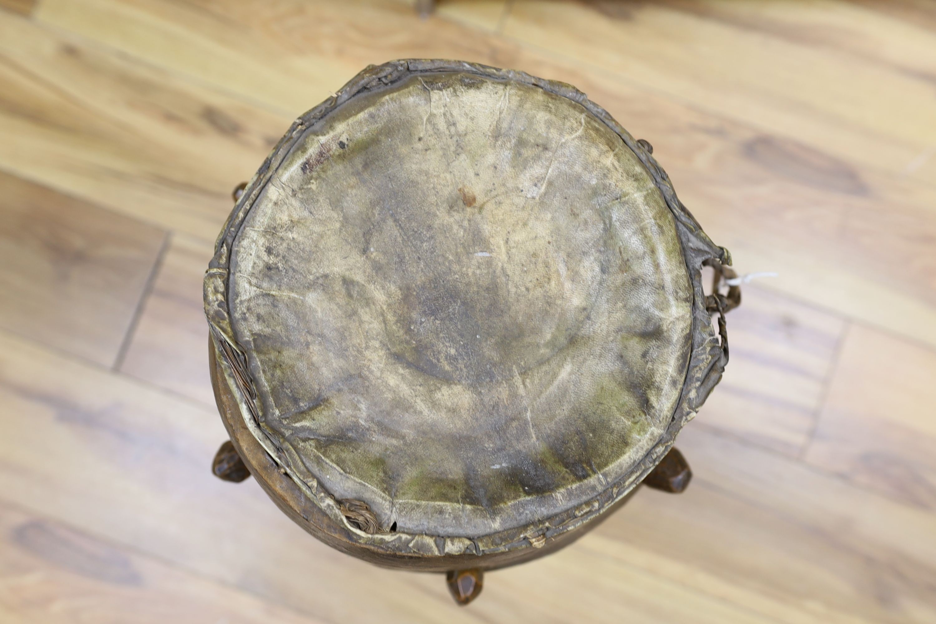 A 19th/20th century Ashanti breasted drum, 61 cms high.